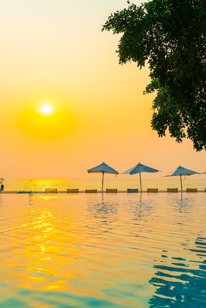 Sombrilla y silla alrededor de la piscina con vista al mar