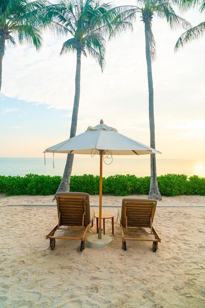 sombrilla con silla de playa y fondo marino - concepto de vacaciones y vacaciones