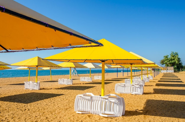 Una sombrilla del sol con tumbonas en la playa.