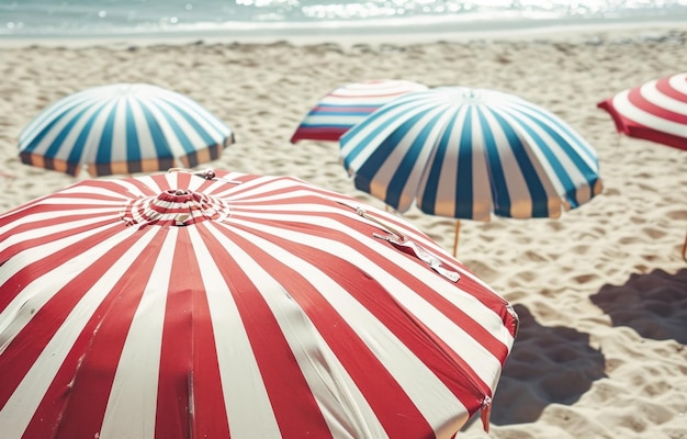 sombrillas de rayas rojas, blancas y azules en una playa de arena