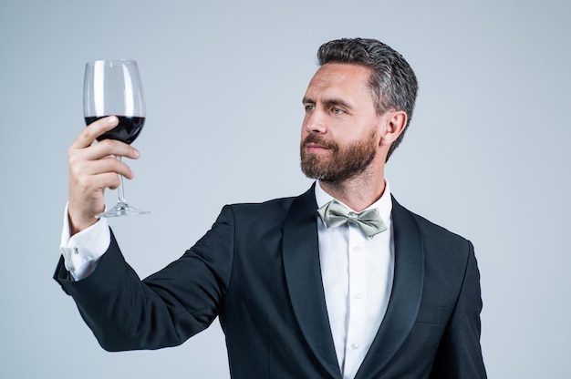 Un sommelier bebe vino tinto aplausos para el día de san valentín bebe alcohol guapo en una cita romántica barman profesional en un evento formal hombre con copa de vino barman experto