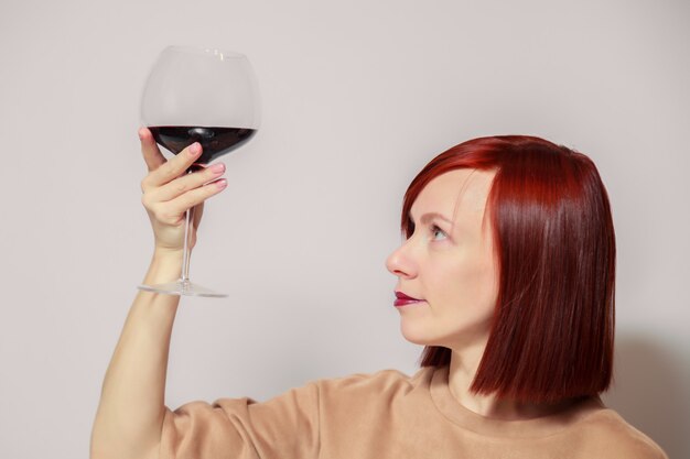 Foto sommelier engraçado jovem mulher ruiva com copo de vinho