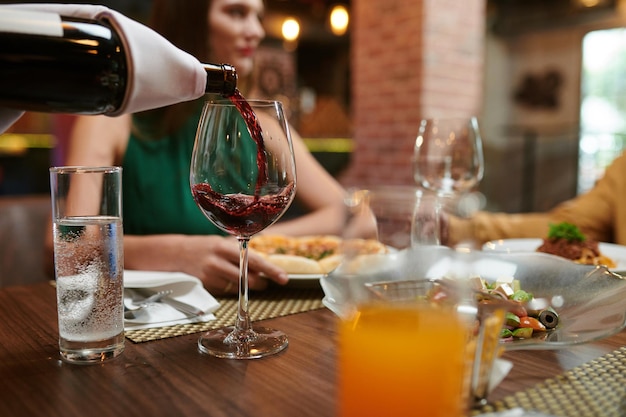 Sommelier gießt Wein in Glas