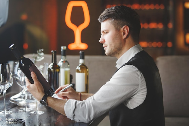 Sommelier olha para garrafa de vinho caro no restaurante