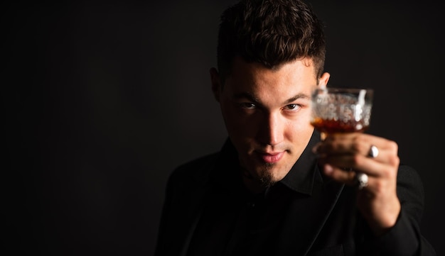 Sommelier prova bebida cara empresário em terno elegante bebida conhaque barman sexy com bebida de luxo mens club hora de relaxar homem de mau hábito segurando conhaque na mão cópia espaço