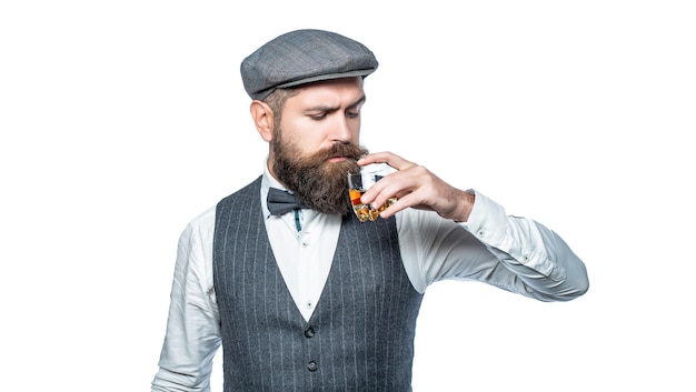 Sommelier prueba una bebida cara Hombre barbudo vestido con traje y bebiendo whisky brandy coñac Barbudo está sosteniendo un vaso de whisky