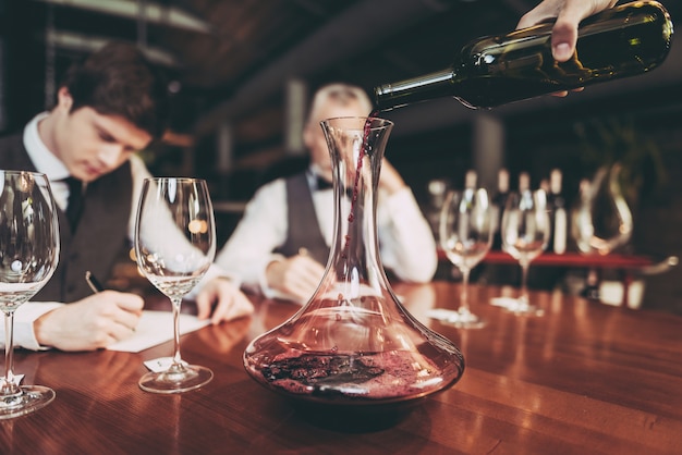 Sommeliers está escrevendo notas sobre as qualidades de sabor do vinho.