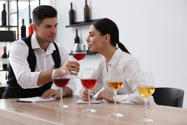 Sommeliers verkosten verschiedene Weinsorten am Tisch drinnen