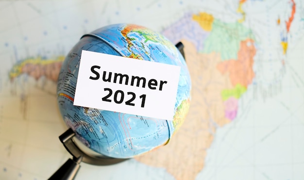Sommer 2021 - Text auf einem weißen Blatt in der Hand vor dem Hintergrund der Atlas-Karte
