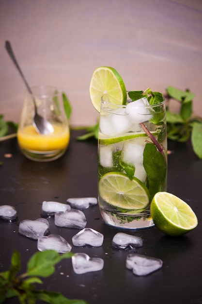 Sommer-Coctail-Mojito mit Eis, Minze, Limette auf grauem Hintergrund. Speicherplatz kopieren.