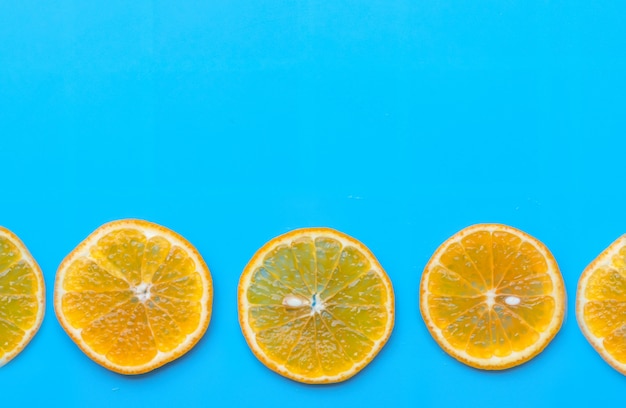 Foto sommer der orange frucht der scheibe auf blauem hintergrund.