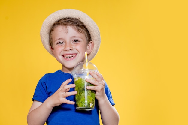 Sommer Erfrischung. Kaltes Getränk. Kleiner Junge mit Plastikbecher frischer Limonade