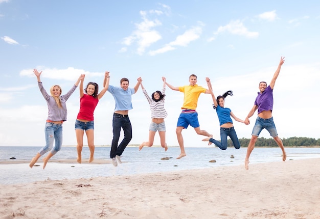 Sommer, Ferien, Urlaub, Konzept der glücklichen Menschen - Gruppe von Freunden, die am Strand springen