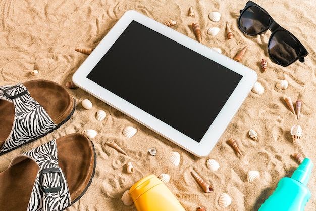 Sommer Flipflops Tablet-Sonnenbrille und Muschel auf Sand mit Platz für Ihre Text-Draufsicht