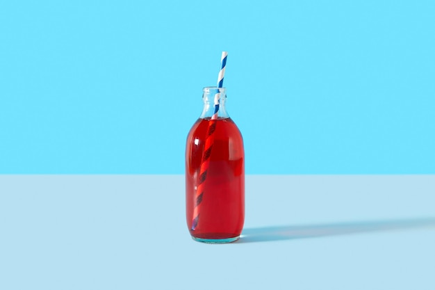 Sommer gefrorener Cranberry-Punch-Cocktail in der Flasche auf blauem Hintergrund