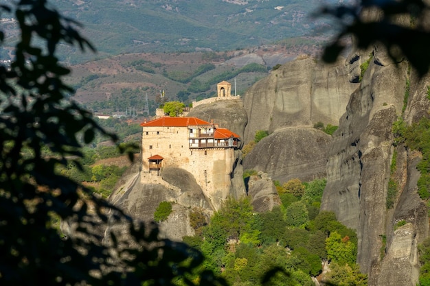 Sommer Griechenland. Sonniger Tag in Meteora. Kloster auf einer hohen Klippe, umgeben von Laub