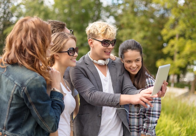 Foto sommer, internet, soziale netzwerke, technologie und jugendliches konzept - gruppe von jugendlichen, die draußen mit tablet-pc fotografieren