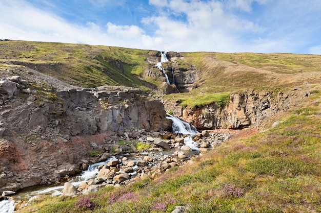 Sommer-Island-Landschaft mit Wasserfall und strahlend blauem Himmel