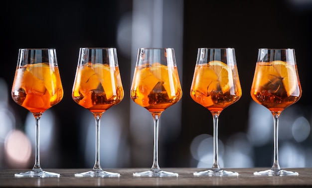 Sommer-Sektgetränk Aperol Spritz serviert in Weingläsern mit Aperol, Prosecco, Soda und einer Orangenscheibe.