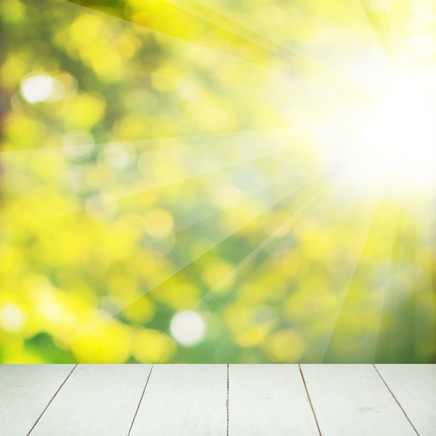 Sommer-Soft-Fokus-Hintergrund mit abstraktem grünem und gelbem Bokeh und leerem Holzbrett mit Kopierraum