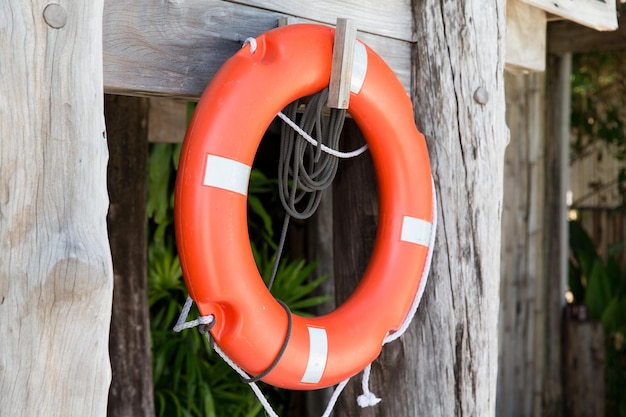 sommer, strand, schwimmen und lebensrettendes konzept - rettungsring oder rettungsring, der an der rettungskabine hängt