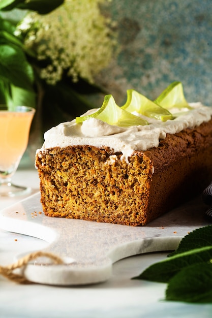 Sommer süßer Laib Kuchen auf einem Tisch mit Blumen und einem Getränk in Gläsern.