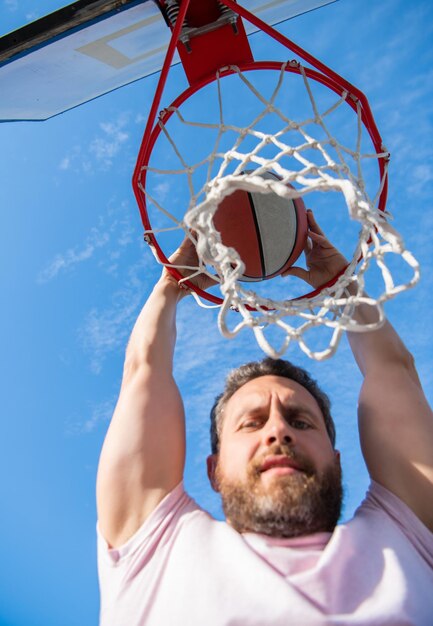 Sommeraktivität Mann mit Basketballball auf dem Platz professionelles Basketballspielertraining