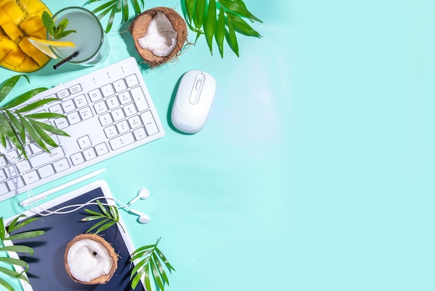 Sommerarbeit freiberufliche Kombination von Arbeit und Freizeit Urlaub Konzept Büro Flatlay mit Tastatur Laptop Tablet Maus Notizblock Palmblätter tropische Früchte und Cocktail Banner Header Draufsicht