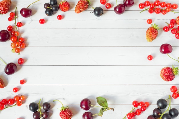 Sommerbeeren Erdbeeren, Johannisbeeren und Kirschen auf weißen Tisch