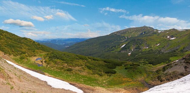 Sommerbergblick mit Schnee am Berghang mit Observatoriumsruinen auf Chornogora Ridge Ukraine