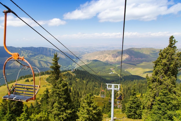 Sommerberglandschaft hoch in den Bergen Hohe Bäume von Weihnachtsbäumen Skilift an der Skibasis