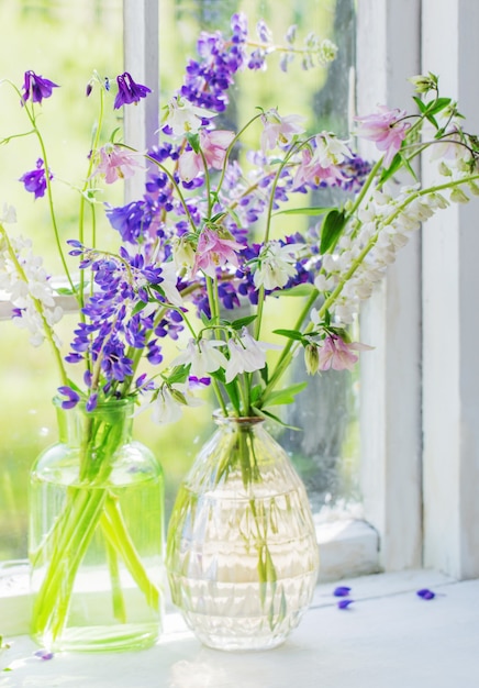 Sommerblumen in der Vase auf der Fensterbank im Sonnenlicht