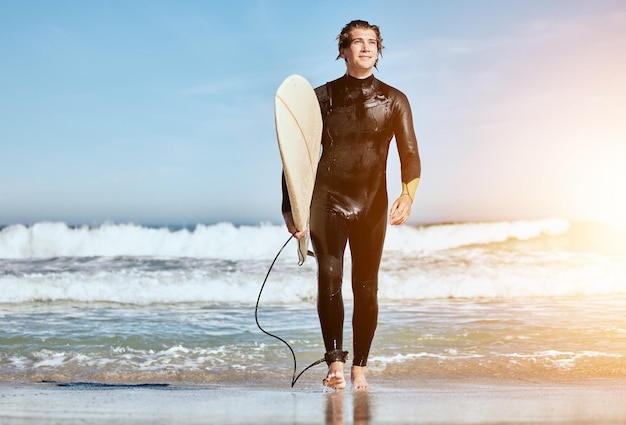 Sommerdenken und Mann am Strand zum Surftraining und glücklich durch die Wellen auf Hawaii Wasserreisen und Surfer mit Brett für Sportruhe und Idee mit Fackel im Urlaub am Meer