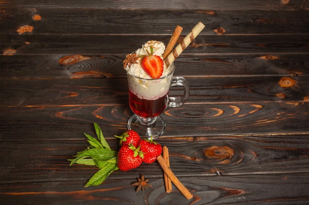 Sommerdessert Erdbeeren und Sahne auf einem Holztisch