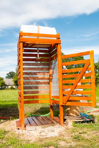 Sommerdusche auf dem Land aus Holzbrettern und Fässern