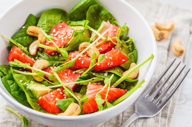 Sommererdbeeravocadosalat mit Acajoubäumen in einer weißen Schüssel.