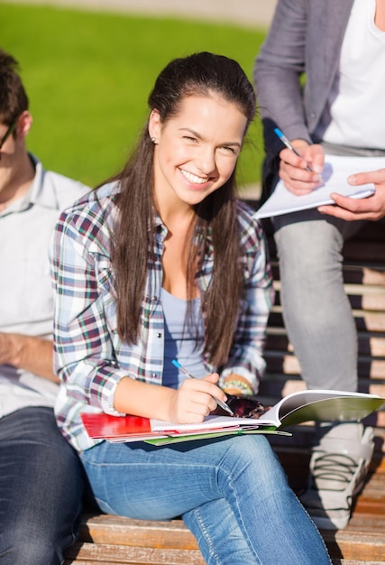 Sommerferien, Bildung, Campus und Jugendkonzept - Gruppe von Studenten oder Jugendlichen mit Büchern, Notizbüchern, Dateien und Ordnern