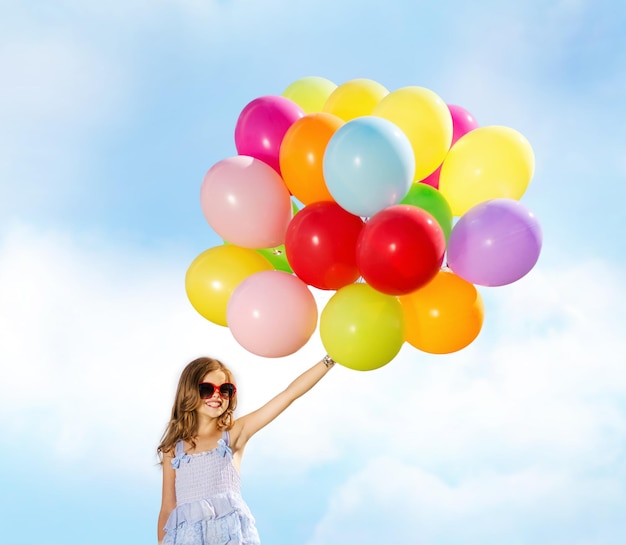 sommerferien, feier, familie, kinder und personenkonzept - glückliches mädchen mit bunten luftballons