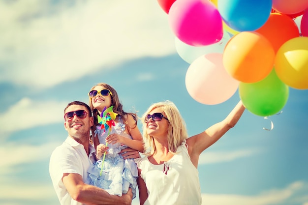 sommerferien, feier, kinder- und menschenkonzept - familie mit bunten luftballons