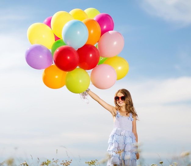 Sommerferien, Feiern, Familien-, Kinder- und Menschenkonzept - glückliches Mädchen mit bunten Luftballons