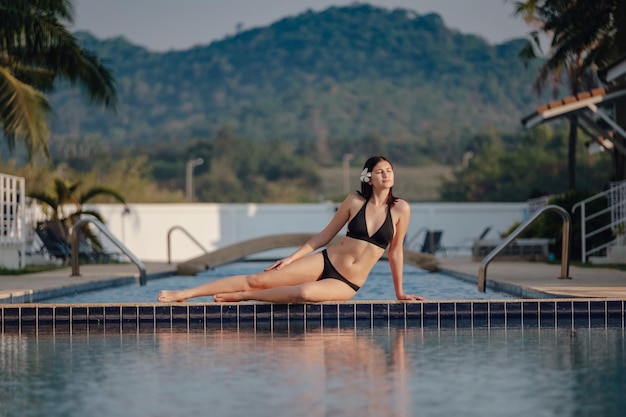 Sommerferien im Luxushotel Frau entspannt sich in der Nähe eines schönen Swimmingpools Schönheits- und Körperpflege Rückansicht ohne Gesicht