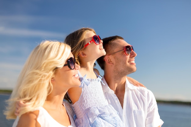 sommerferien, kinder- und menschenkonzept - glückliche familie mit blauem himmel