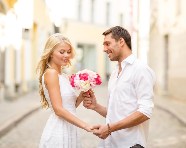 Sommerferien, Liebe, Beziehung und Dating-Konzept - Paar mit Blumenstrauß in der Stadt