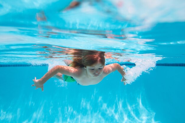 Sommerferien mit Kindern unter Wasser Kind schwimmt im Pool gesundes Kind schwimmt und hat Spaß u