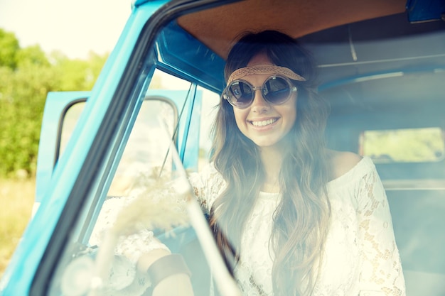 sommerferien, road trip, urlaub, reise- und personenkonzept - lächelnde junge hippie-frauen im minivan-auto