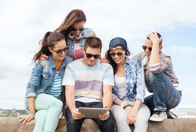 Sommerferien, Teenager- und Technologiekonzept - Gruppe von Teenagern, die Tablet-PC betrachten