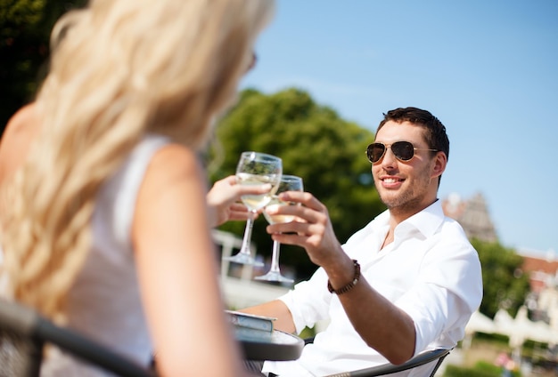 Sommerferien und Dating-Konzept - Mann trinkt Wein mit Frau im Café in der Stadt