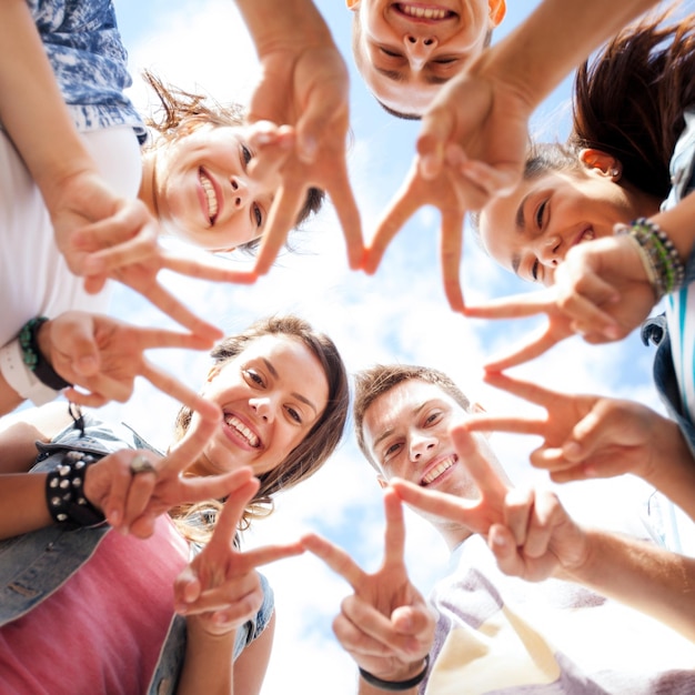 Foto sommerferien und jugendliches konzept - gruppe von jugendlichen, die finger fünf gesten zeigen