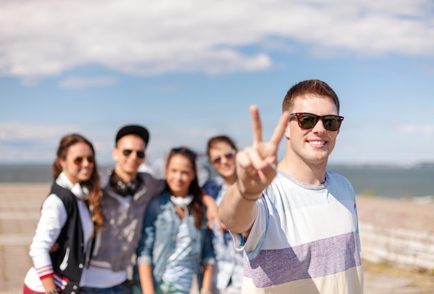 Sommerferien und Teenager-Konzept - Teenager mit Sonnenbrille, die draußen mit Freunden rumhängt