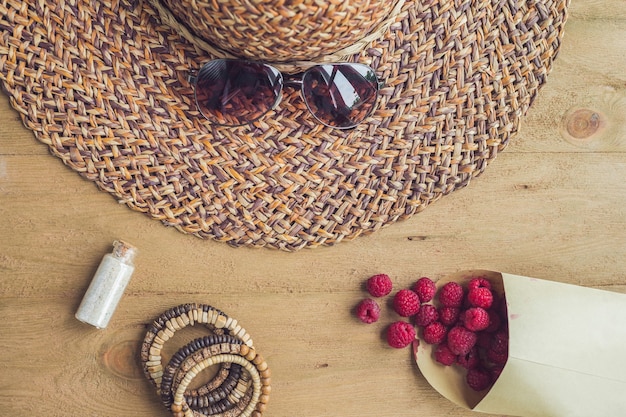 Sommerferien Urlaub Entspannung Konzept Himbeeren Strohhut Smartphone Sonnenbrille von oben